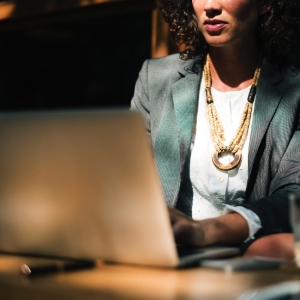 Woman sitting at the laptop sitting with the sun on her